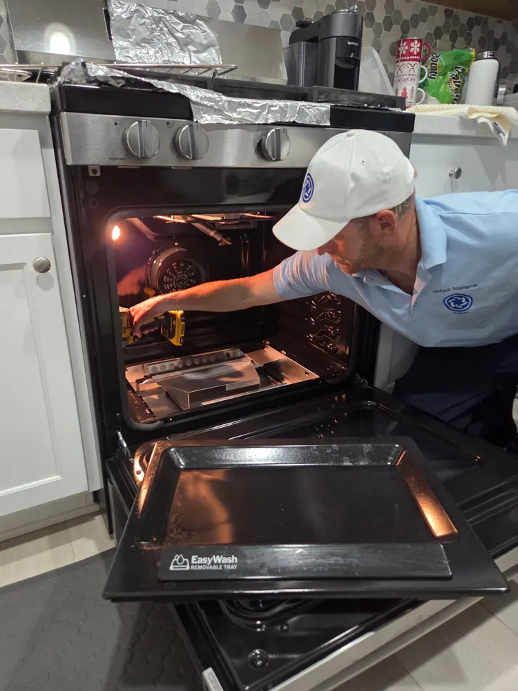Jackpot technician repairing a gas range oven in a Las Vegas kitchen