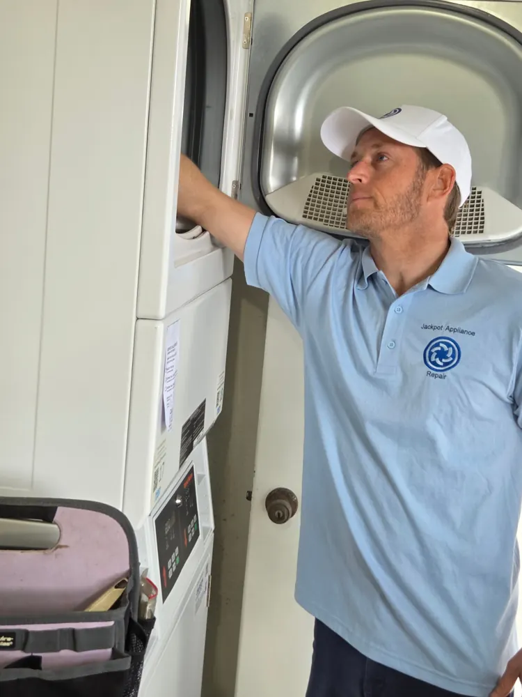 Technician checking a stacked commercial washer and dryer
